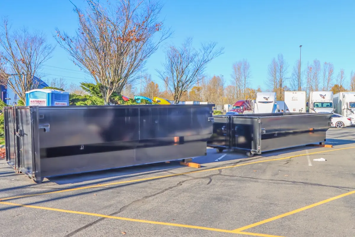 Professional dumpster rental service with roll-off container on residential driveway in Grinnell